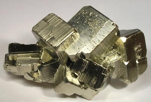 Brassy pyrite cubes whose square faces carry parallel striations, each face striated at right angles to its neighbors.